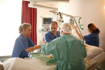 Drei Pflegende und ein Arzt behandeln einen Patienten