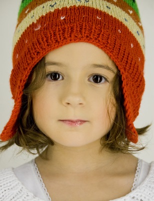 Kind mit bunter Mütze blickt direkt in die Kamera