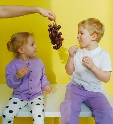 Mädchen und Junge essen Trauben